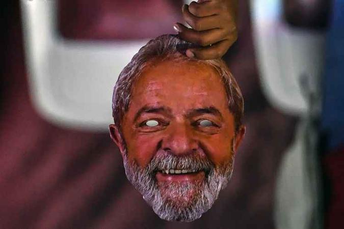 Um homem segura uma máscara do ex-presidente brasileiro Luis Inácio Lula da Silva, preso em Curitiba, durante a convenção nacional do Partido dos Trabalhadores (PT)(foto: Nelson Almeida) Um homem segura uma máscara do ex-presidente brasileiro Luis Inácio Lula da Silva, preso em Curitiba, durante a convenção nacional do Partido dos Trabalhadores (PT)(foto: Nelson Almeida)