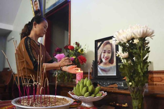 Um parente acende um incenso em frente ao retrato de Bui Thi Nhung(foto: Nhac Nguyen / AFP ) Um parente acende um incenso em frente ao retrato de Bui Thi Nhung(foto: Nhac Nguyen / AFP )