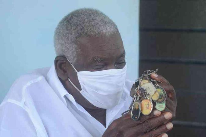 Com objetos de fé, mas sem abrir mão da proteção da máscara, Mário Braz da Luz, da Comunidade dos Arturos, diz que nunca viu nada parecido em seus 87 anos(foto: Leandro Couri/EM) Com objetos de fé, mas sem abrir mão da proteção da máscara, Mário Braz da Luz, da Comunidade dos Arturos, diz que nunca viu nada parecido em seus 87 anos(foto: Leandro Couri/EM)