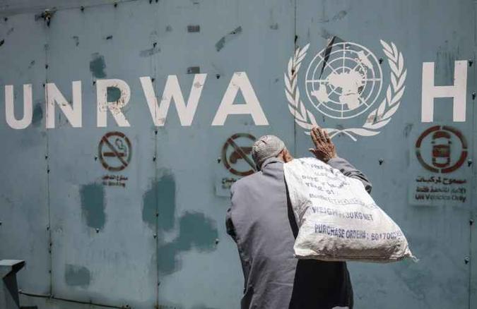 Imagem mostra palestino em frente ao logo da Agência das Nações Unidas de Assistência aos Refugiados da Palestina no Próximo Oriente (foto: Said Khatib/Arquivos ) Imagem mostra palestino em frente ao logo da Agência das Nações Unidas de Assistência aos Refugiados da Palestina no Próximo Oriente (foto: Said Khatib/Arquivos )