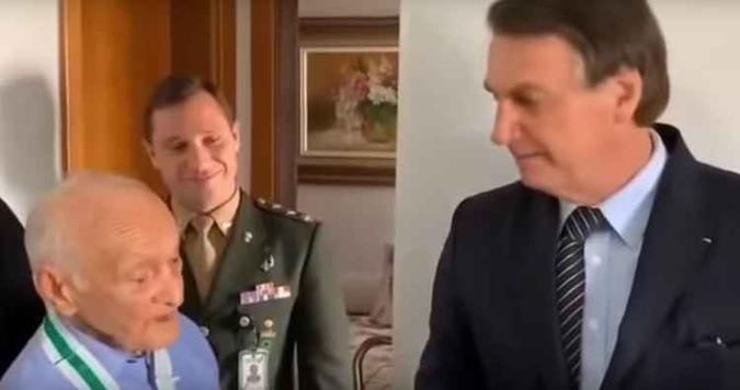 O segundo tenente Carlos Santiago de Amorim recebe a visita de Bolsonaro em seu apartamento, em Brasília(foto: Youtube/Reprodução) O segundo tenente Carlos Santiago de Amorim recebe a visita de Bolsonaro em seu apartamento, em Brasília(foto: Youtube/Reprodução)