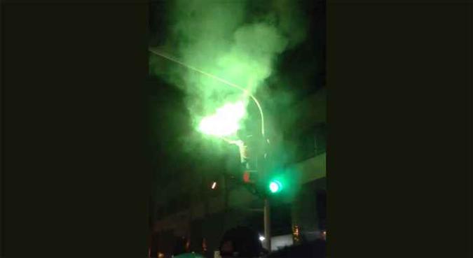 Um dos vídeos mostra o momento em que um jovem subiu no semáforo e acendeu um sinalizador verde(foto: Reprodução de internet) Um dos vídeos mostra o momento em que um jovem subiu no semáforo e acendeu um sinalizador verde(foto: Reprodução de internet)