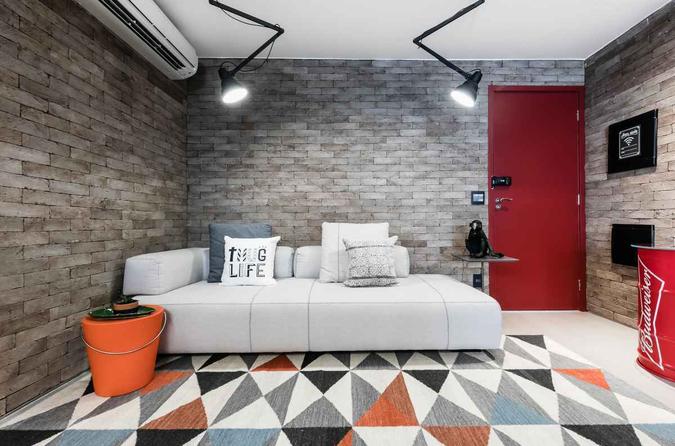 Na sala projetada por Luiz Paulo Andrade, a porta vermelha contrasta com os tijolos acinzentados e harmoniza com o tom laranja da mesa de apoio(foto: ATA Photograph) Na sala projetada por Luiz Paulo Andrade, a porta vermelha contrasta com os tijolos acinzentados e harmoniza com o tom laranja da mesa de apoio(foto: ATA Photograph)