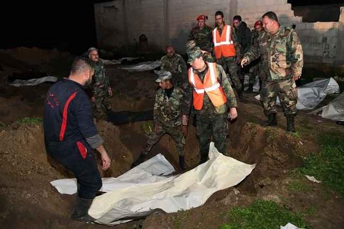 O exército sírio descobriu uma vala comum contendo cerca de 70 corpos em um antigo bastião rebelde perto de Damasco.(foto: AFP PHOTO / HO / SANA) O exército sírio descobriu uma vala comum contendo cerca de 70 corpos em um antigo bastião rebelde perto de Damasco.(foto: AFP PHOTO / HO / SANA)