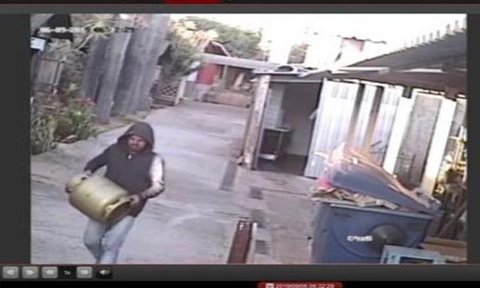 As câmeras do Lar dos Velhinhos capturaram um dos momentos em que o suspeito sai com um dos botijões de gás(foto: Reprodução) As câmeras do Lar dos Velhinhos capturaram um dos momentos em que o suspeito sai com um dos botijões de gás(foto: Reprodução)