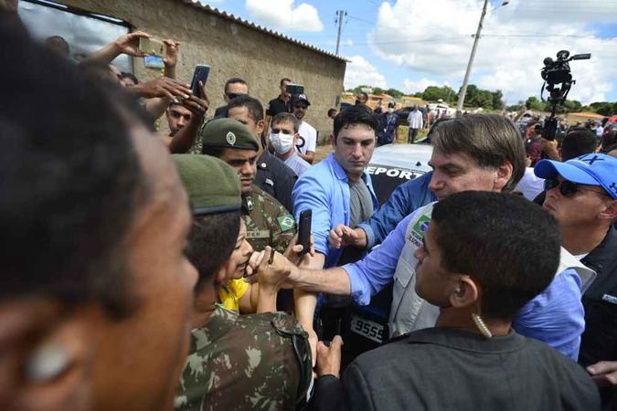 Bolsonaro pega na mão de mulher em Águas Lindas de Goiás(foto: Marcelo Ferreira/CB/D.A Press) Bolsonaro pega na mão de mulher em Águas Lindas de Goiás(foto: Marcelo Ferreira/CB/D.A Press)