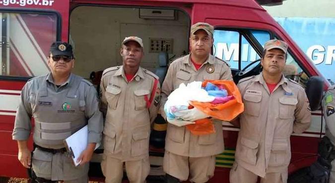 A criança com a equipe que a resgatou: pai e mãe não foram identificados(foto: Divulgação/Bombeiros Goiás) A criança com a equipe que a resgatou: pai e mãe não foram identificados(foto: Divulgação/Bombeiros Goiás)
