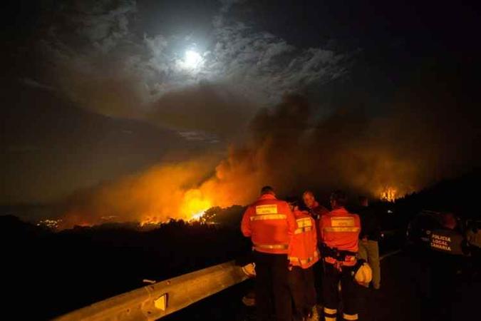 Bombeiros avaliando os picos de incêndio (foto: AFP) Bombeiros avaliando os picos de incêndio (foto: AFP)