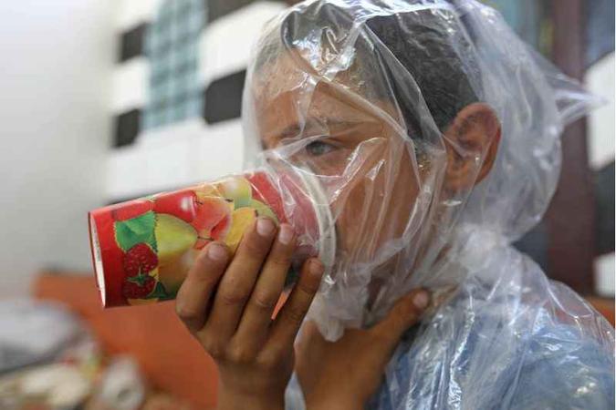 Em Maar Shurin, na província de Idlib, criança testa máscara antigás improvisada pelo pai: medo constante(foto: Omar Haj Kadour/AFP) Em Maar Shurin, na província de Idlib, criança testa máscara antigás improvisada pelo pai: medo constante(foto: Omar Haj Kadour/AFP)
