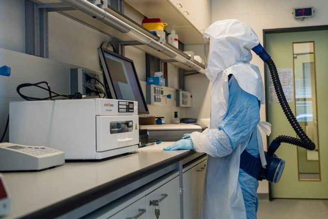 Com roupas de proteção, cientistas trabalham em laboratório de alta segurança na Alemanha: empresas interessadas na realização de testes clínicos(foto: AFP / JENS SCHLUETER) Com roupas de proteção, cientistas trabalham em laboratório de alta segurança na Alemanha: empresas interessadas na realização de testes clínicos(foto: AFP / JENS SCHLUETER)