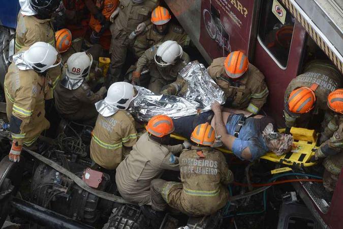 Bombeiros retiram maquinista das ferragens após colisão no Rio (foto: Fernando Frazão/Agência Brasil) Bombeiros retiram maquinista das ferragens após colisão no Rio (foto: Fernando Frazão/Agência Brasil)