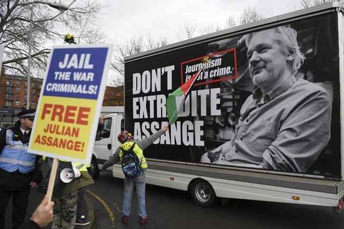 Os apoiadores do fundador do WikiLeaks, Julian Assange, seguram cartazes enquanto um outdoor é dirigido ao pedir a liberdade de Assange do lado de fora da Woolwich Crown Court, no sudeste de Londres, em 24 de fevereiro de 2020, antes da abertura da audiência completa em um pedido americano de extradição de Assange. (foto: DANIEL LEAL-OLIVAS / AFP) Os apoiadores do fundador do WikiLeaks, Julian Assange, seguram cartazes enquanto um outdoor é dirigido ao pedir a liberdade de Assange do lado de fora da Woolwich Crown Court, no sudeste de Londres, em 24 de fevereiro de 2020, antes da abertura da audiência completa em um pedido americano de extradição de Assange. (foto: DANIEL LEAL-OLIVAS / AFP)
