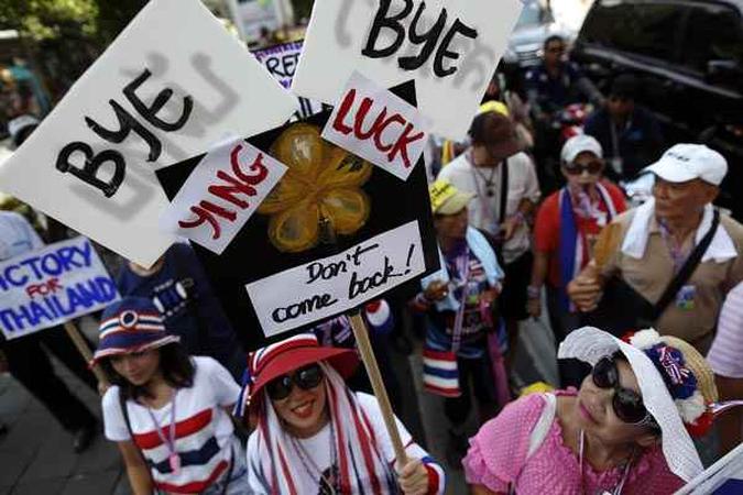 Em protesto, manifestantes anti-governo carregam cartazes contra o deposto primeiro-ministro Yingluck Shinawatra(foto: Damir Sagolj/Reuters) Em protesto, manifestantes anti-governo carregam cartazes contra o deposto primeiro-ministro Yingluck Shinawatra(foto: Damir Sagolj/Reuters)