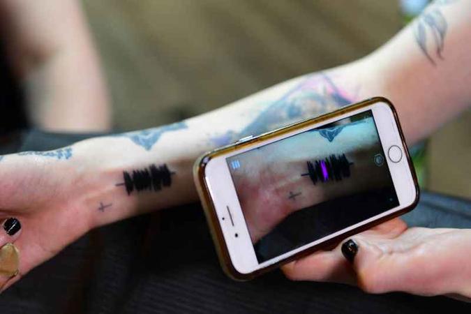 Com o auxílio do celular, Hanna ouve a sua tatoo: Com o auxílio do celular, Hanna ouve a sua tatoo: