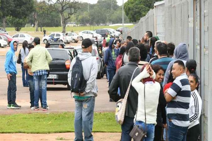 A fila reúne centenas de pessoas, em frente ao Estádio Mané Garrincha, em busca de um emprego(foto: Ed Alves/CB/ DA Press) A fila reúne centenas de pessoas, em frente ao Estádio Mané Garrincha, em busca de um emprego(foto: Ed Alves/CB/ DA Press)