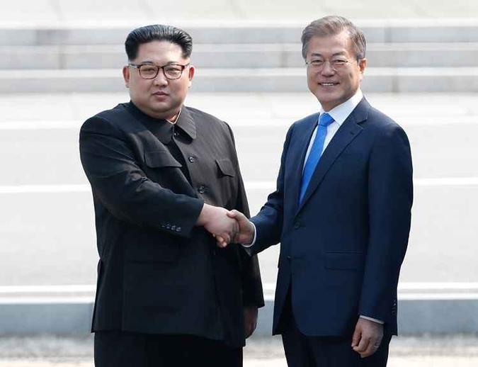 Líder da Coreia do Norte Kim Jong Un apertando as mãos do Presidente da Coreia do Sul Moon Jae-in na Linha de Demarcação Militar que divide as coreias.(foto: Korea Summit Press Pool / AFP) Líder da Coreia do Norte Kim Jong Un apertando as mãos do Presidente da Coreia do Sul Moon Jae-in na Linha de Demarcação Militar que divide as coreias.(foto: Korea Summit Press Pool / AFP)