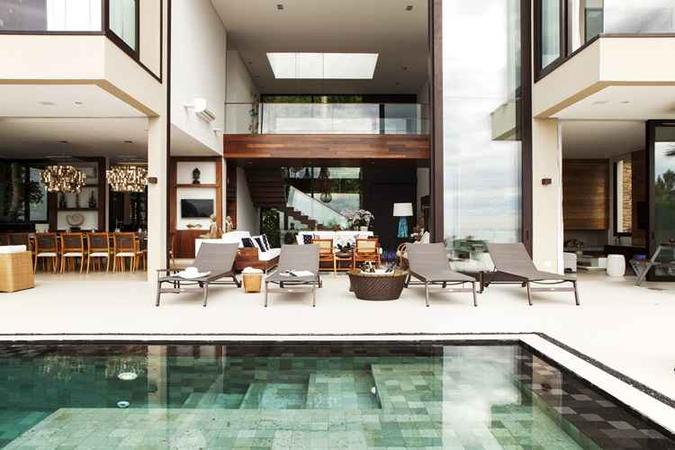 No projeto da arquiteta Karina Korn, a área de piscina é integrada aos demais ambientes da casa e se utiliza de lounges para criar uma atmosfera propícia a reuniões e confraternizações. (foto: Dc33/ Divulgação) No projeto da arquiteta Karina Korn, a área de piscina é integrada aos demais ambientes da casa e se utiliza de lounges para criar uma atmosfera propícia a reuniões e confraternizações. (foto: Dc33/ Divulgação)