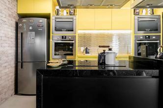 No projeto do arquiteto Luiz Paulo Andrade os armários em amarelo, combinado aos tons preto, inox e aos detalhes do revestimento de tijolos trazem ao espaço um ar jovem e moderno. O batente em vermelho completa o visual descontraído da cozinha.(foto: Crédito: Andre Toledo Araujo/Divulgação) No projeto do arquiteto Luiz Paulo Andrade os armários em amarelo, combinado aos tons preto, inox e aos detalhes do revestimento de tijolos trazem ao espaço um ar jovem e moderno. O batente em vermelho completa o visual descontraído da cozinha.(foto: Crédito: Andre Toledo Araujo/Divulgação)