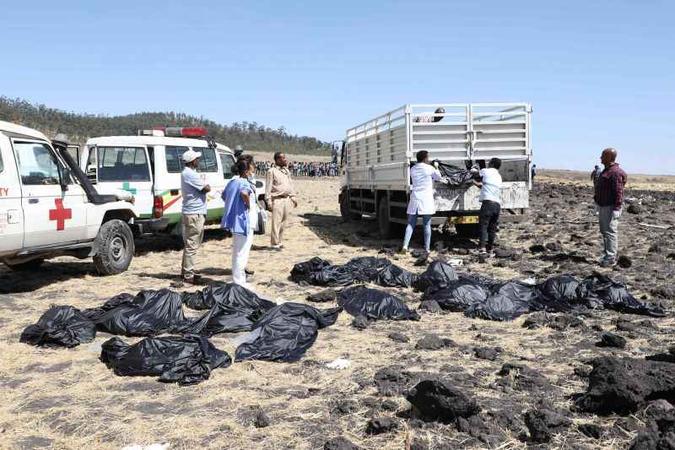 Corpos são resgatados por equipe após acidente de avião na Etiópia (foto: AFP / Michael TEWELDE ) Corpos são resgatados por equipe após acidente de avião na Etiópia (foto: AFP / Michael TEWELDE )