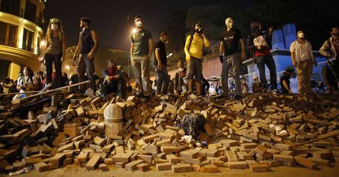 Militantes fazem barricadas nas ruas e usam máscaras para se livrar das bombas de gás lacrimogêneo lançadas por policiais durante confrontos que ocorrem há dias(foto: Murad Seze/Reuters) Militantes fazem barricadas nas ruas e usam máscaras para se livrar das bombas de gás lacrimogêneo lançadas por policiais durante confrontos que ocorrem há dias(foto: Murad Seze/Reuters)