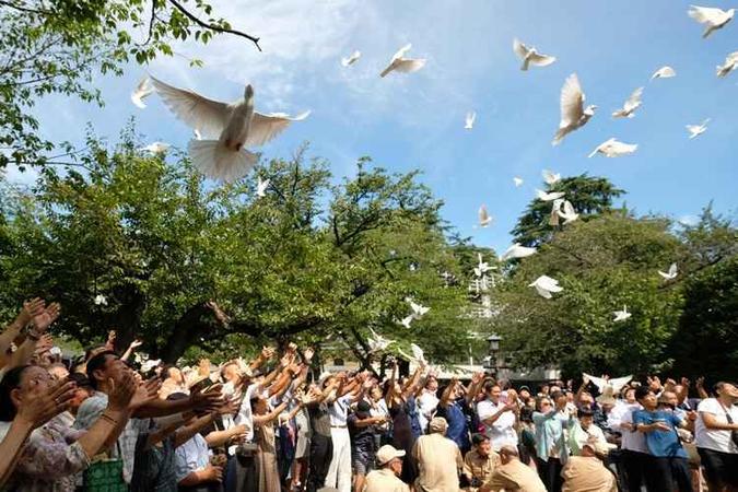 Pessoas libertam pombas para homenagear os mortos no santuário de Yasukuni no 73º aniversário da rendição do Japão na Segunda Guerra Mundial (foto: Kazuhiro Nogi/AFP) Pessoas libertam pombas para homenagear os mortos no santuário de Yasukuni no 73º aniversário da rendição do Japão na Segunda Guerra Mundial (foto: Kazuhiro Nogi/AFP)