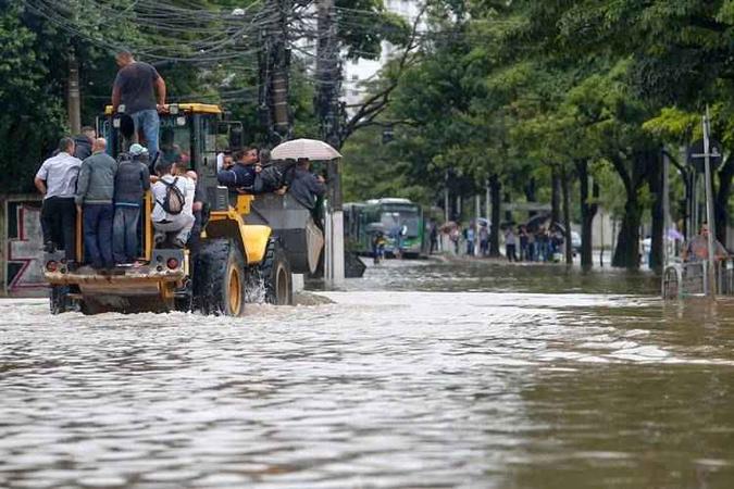 Paulistanos pegam carona em trator após o dilúvio: em três horas, o volume de água chegou 100 milímetros. Vários locais ficaram intransitáveis(foto: Miguel Schincariol/AFP) Paulistanos pegam carona em trator após o dilúvio: em três horas, o volume de água chegou 100 milímetros. Vários locais ficaram intransitáveis(foto: Miguel Schincariol/AFP)