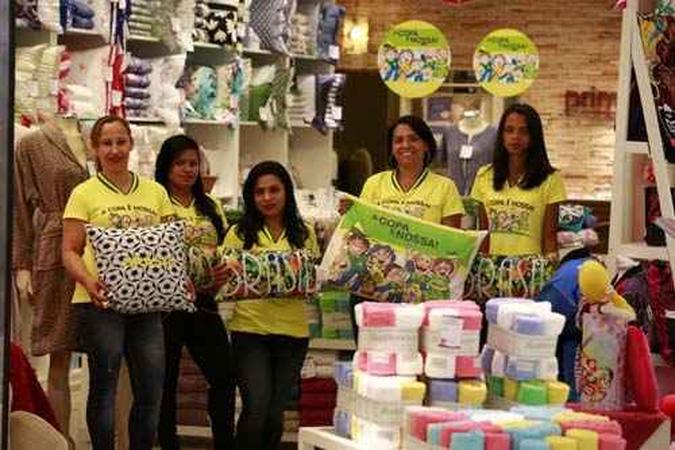 Funcionários de loja de roupas de cama mostram almofadas e travesseiros com o tema do torneio, uma das apostas para faturar com a animação dos torcedores da capital (foto: Daniel Ferreira/CB/D.A Press) Funcionários de loja de roupas de cama mostram almofadas e travesseiros com o tema do torneio, uma das apostas para faturar com a animação dos torcedores da capital (foto: Daniel Ferreira/CB/D.A Press)