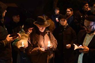 Pessoas seguram velas e oram em frente à sinagoga onde ocorreu o ataque(foto: AFP) Pessoas seguram velas e oram em frente à sinagoga onde ocorreu o ataque(foto: AFP)