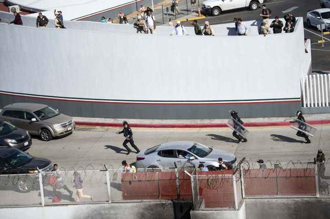 Migrantes tentaram neste domingo (25) pular a cerca fronteiriça que separa o México dos Estados Unidos, em Tijuana(foto: AFP / Pedro Pardo) Migrantes tentaram neste domingo (25) pular a cerca fronteiriça que separa o México dos Estados Unidos, em Tijuana(foto: AFP / Pedro Pardo)