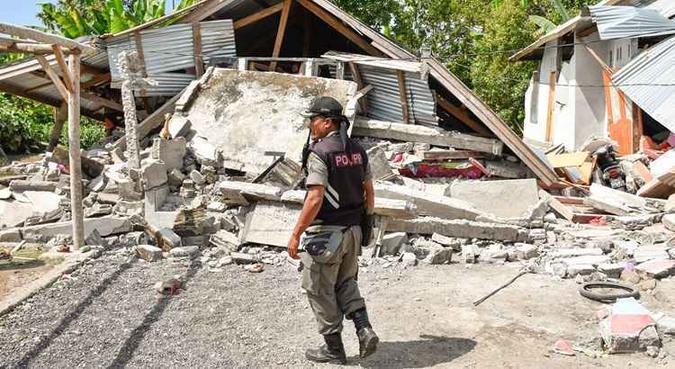 Um oficial de segurança da aldeia indonésia examina os restos de casas, após um terremoto de magnitude 6,4, em Lombok(foto: Aulia Ahmad/AFP ) Um oficial de segurança da aldeia indonésia examina os restos de casas, após um terremoto de magnitude 6,4, em Lombok(foto: Aulia Ahmad/AFP )