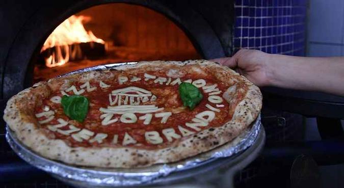 Além do espetacular manejo da massa, esta é uma habilidade culinária que associa canções, sorrisos, técnica, espetáculo, iniciada no século XVI, ressaltava a candidatura italiana(foto: Tiziana Fabi/AFP ) Além do espetacular manejo da massa, esta é uma habilidade culinária que associa canções, sorrisos, técnica, espetáculo, iniciada no século XVI, ressaltava a candidatura italiana(foto: Tiziana Fabi/AFP )