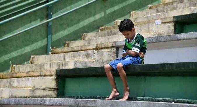 Foto de menino torcedor sentado em arquibancada do estádio da Chapecoense viralizou na web(foto: Nelson Almeida/AFP) Foto de menino torcedor sentado em arquibancada do estádio da Chapecoense viralizou na web(foto: Nelson Almeida/AFP)