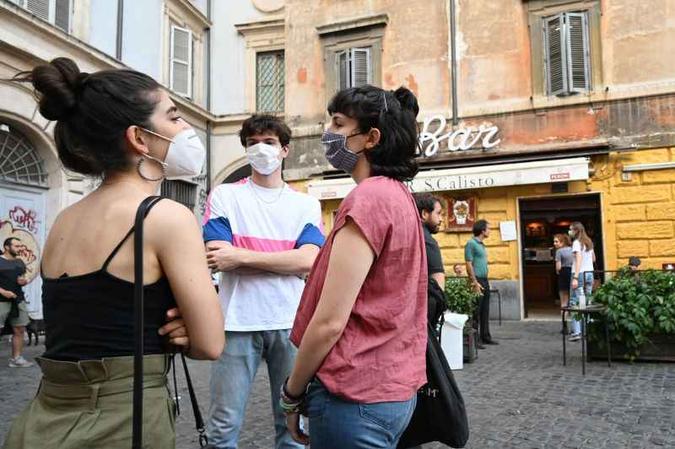 Jovens em rua italiana: algumas regiões proibiram até mesmo o abraço para conter a covid-19(foto: Miguel Medina/AFP) Jovens em rua italiana: algumas regiões proibiram até mesmo o abraço para conter a covid-19(foto: Miguel Medina/AFP)