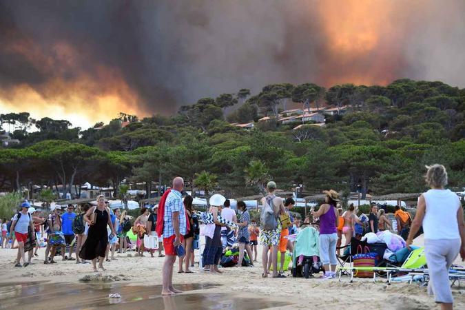 Pessoas fogem do fogo em praia na França (26/7)(foto: CRÉDITOANNE-CHRISTINE POUJOULAT / AFP ) Pessoas fogem do fogo em praia na França (26/7)(foto: CRÉDITOANNE-CHRISTINE POUJOULAT / AFP )