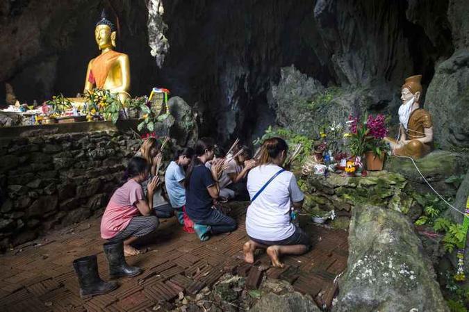 Familiares de crianças e do técnico isolados na caverna de Tham Luang oram na entrada da galeria subterrânea: o tempo como ameaça (foto: AFP PHOTO / Ye Aung THU ) Familiares de crianças e do técnico isolados na caverna de Tham Luang oram na entrada da galeria subterrânea: o tempo como ameaça (foto: AFP PHOTO / Ye Aung THU )