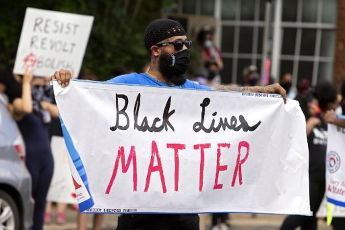 Um homem segura uma faixa do Black Lives Matter durante um protesto pela justiça racial em Charlottesville em 30 de maio de 2020. Manifestações estão sendo realizadas nos EUA depois que George Floyd morreu sob custódia policial em 25 de maio.(foto: Ryan M. Kelly / AFP) Um homem segura uma faixa do Black Lives Matter durante um protesto pela justiça racial em Charlottesville em 30 de maio de 2020. Manifestações estão sendo realizadas nos EUA depois que George Floyd morreu sob custódia policial em 25 de maio.(foto: Ryan M. Kelly / AFP)