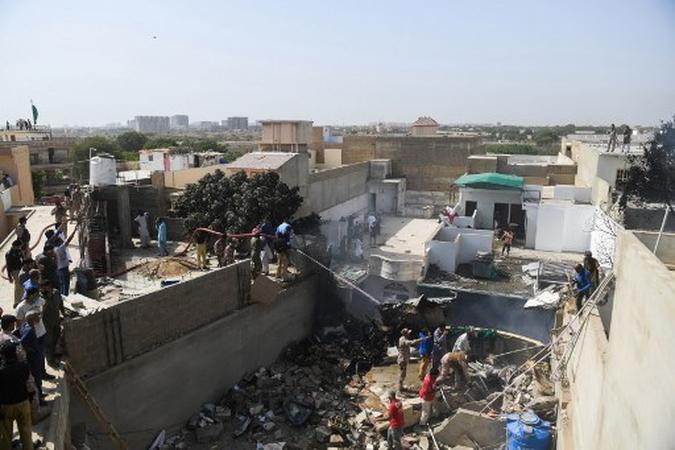 Os trabalhadores de resgate pulverizam água por parte de uma aeronave da Pakistan International Airlines depois que ela caiu em uma área residencial em Karachi em 22 de maio de 2020. (foto: Asif HASSAN / AFP) Os trabalhadores de resgate pulverizam água por parte de uma aeronave da Pakistan International Airlines depois que ela caiu em uma área residencial em Karachi em 22 de maio de 2020. (foto: Asif HASSAN / AFP)
