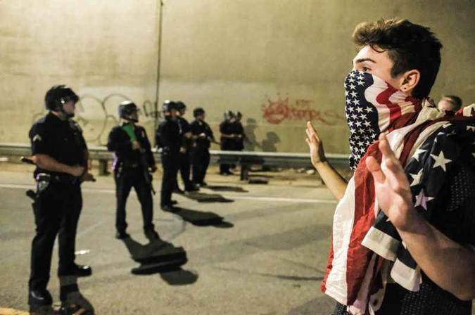 Jovem confronta policiais durante bloqueio da Rodovia 101, em Los Angeles: 28 ativistas foram presos em ato que reuniu 3 mil(foto: Ringo Chiu/AFP) Jovem confronta policiais durante bloqueio da Rodovia 101, em Los Angeles: 28 ativistas foram presos em ato que reuniu 3 mil(foto: Ringo Chiu/AFP)