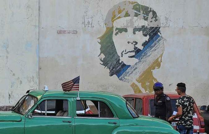 Carro com bandeira dos EUA em frente a um graffite de Che Guevara em Cuba(foto: YAMIL LAGE) Carro com bandeira dos EUA em frente a um graffite de Che Guevara em Cuba(foto: YAMIL LAGE)