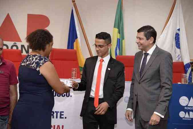 Leonardo recebe das mãos da mãe, Gercina, a carteirinha de advogado(foto: Vital Vaz / - Assessoria de Imprensa da OAB/RO)
