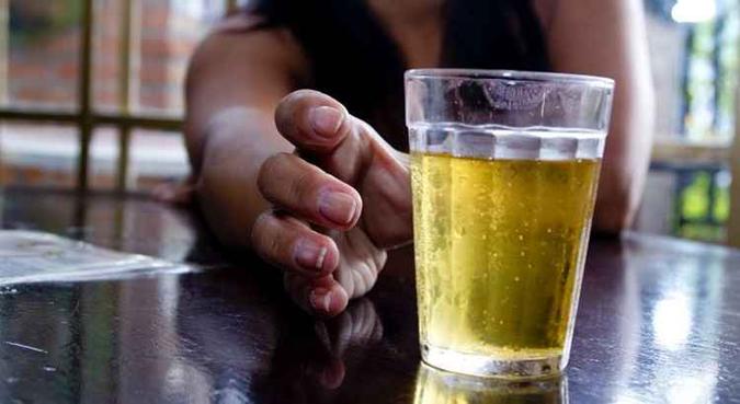 Mulher leva mão a copo de cerveja(foto: Marcos Santos/USP Imagens) Mulher leva mão a copo de cerveja(foto: Marcos Santos/USP Imagens)