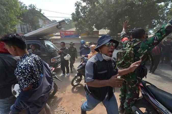 Soldados e funcionários tentam acalmar as pessoas logo após um tremor secundário atingir a área em Tanjung na ilha de Lombok(foto: Adek Berry / AFP) Soldados e funcionários tentam acalmar as pessoas logo após um tremor secundário atingir a área em Tanjung na ilha de Lombok(foto: Adek Berry / AFP)