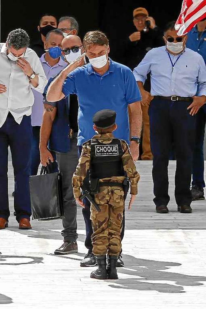 Bolsonaro bate continência para menino fantasiado de policial do choque, na subida da rampa do Planalto. Simpatia, silêncio, aproximação do Centrão e acenos ao social o fazem palatável aos setores populares (foto: Sergio Lima/AFP ) Bolsonaro bate continência para menino fantasiado de policial do choque, na subida da rampa do Planalto. Simpatia, silêncio, aproximação do Centrão e acenos ao social o fazem palatável aos setores populares (foto: Sergio Lima/AFP )
