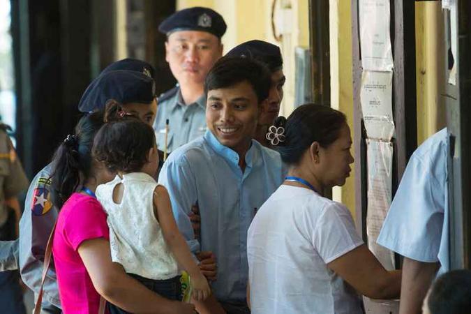 O jornalista cingalês Kyaw Soe Oo (C) sorri para a filha enquanto é levado pela polícia ao tribunal(foto: Sai Aung Main/AFP) O jornalista cingalês Kyaw Soe Oo (C) sorri para a filha enquanto é levado pela polícia ao tribunal(foto: Sai Aung Main/AFP)