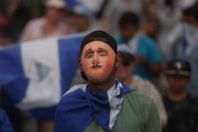Estudante mascarado em marcha (foto: AFP / MARVIN RECINOS ) Estudante mascarado em marcha (foto: AFP / MARVIN RECINOS )