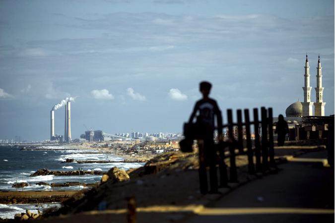Em primeiro plano, o campo de refugiados de Al-Shati, na Faixa de Gaza, com vista para a cidade portuária israelense de Ashkelon, ao fundo: região conturbada (foto: MOHAMMED ABED/AFP) Em primeiro plano, o campo de refugiados de Al-Shati, na Faixa de Gaza, com vista para a cidade portuária israelense de Ashkelon, ao fundo: região conturbada (foto: MOHAMMED ABED/AFP)