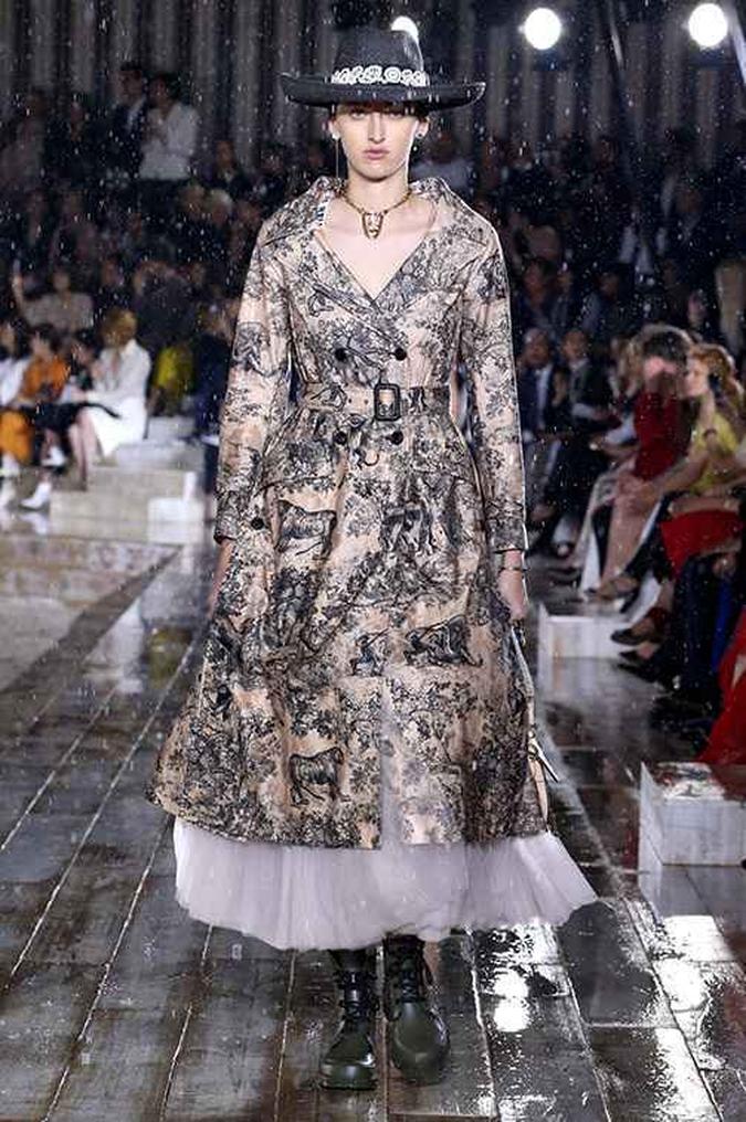 Inspirada no mundo equestre, a Dior colocou na passarela um dualismo entre a seriedade de um trench coat, que apareceu estampado, e o romantismo de uma saia ampla de tule. O coturno pesou os pés, mas o conjunto é inspiração para quem gosta de ousar.(foto: Dior) Inspirada no mundo equestre, a Dior colocou na passarela um dualismo entre a seriedade de um trench coat, que apareceu estampado, e o romantismo de uma saia ampla de tule. O coturno pesou os pés, mas o conjunto é inspiração para quem gosta de ousar.(foto: Dior)