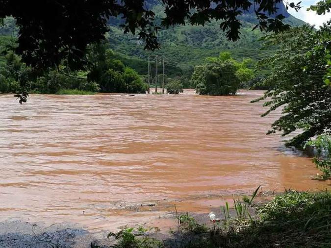 Registros do Bairro Ilha dos Araújos nesta manhã de quarta-feira (7/2) mostram que o nível do rio já encobre troncos de árvores e está próximo das ruas(foto: Flávia Maria/ Divulgação) Registros do Bairro Ilha dos Araújos nesta manhã de quarta-feira (7/2) mostram que o nível do rio já encobre troncos de árvores e está próximo das ruas(foto: Flávia Maria/ Divulgação)