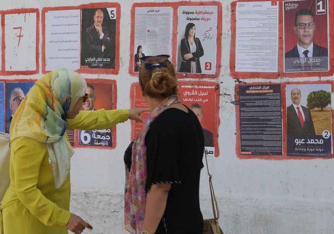 Mulheres tunisianas observam cartazes com fotos dos presidenciáveis, na capital: eleições históricas(foto: Fethi Belaid/AFP ) Mulheres tunisianas observam cartazes com fotos dos presidenciáveis, na capital: eleições históricas(foto: Fethi Belaid/AFP )