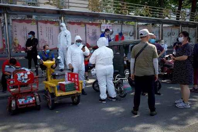 Membros da equipe médica em equipamentos de proteção completa ficam do lado de fora do centro esportivo de Guang'an para ajudar as pessoas que moram perto ou visitaram o Mercado Xinfadi, um mercado atacadista de alimentos onde um novo cluster de coronavírus surgiu, para testes em Pequim em junho 16, 2020.(foto: Noel Celis / AFP) Membros da equipe médica em equipamentos de proteção completa ficam do lado de fora do centro esportivo de Guang'an para ajudar as pessoas que moram perto ou visitaram o Mercado Xinfadi, um mercado atacadista de alimentos onde um novo cluster de coronavírus surgiu, para testes em Pequim em junho 16, 2020.(foto: Noel Celis / AFP)